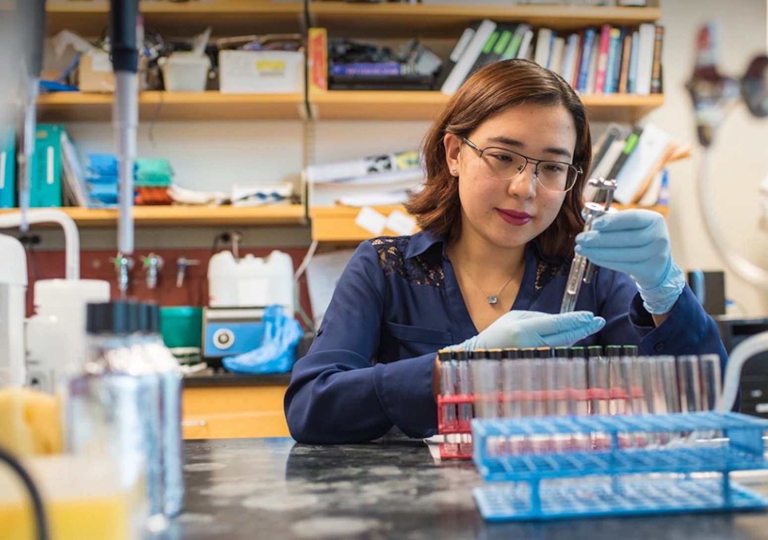 Doctoral student Yi Wen inserts lipids into test tubes as she prepares synthetic membrane vesicles.