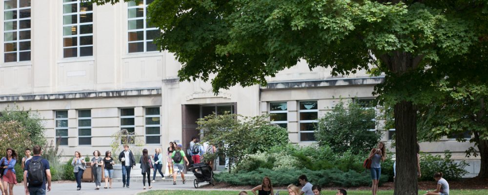 Students outside Mann Library in summer.