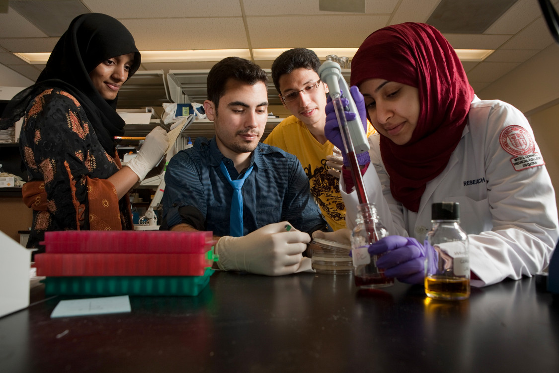 Students grouped around an experiment