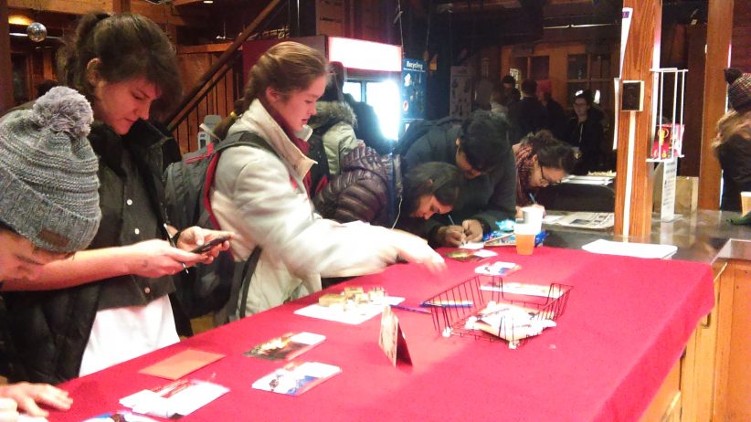 Graduate students filling out postcards in the Big Red Barn as part of the Gratitude Project
