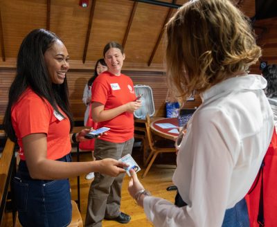 Volunteers hand incoming students IDs at Orientation.