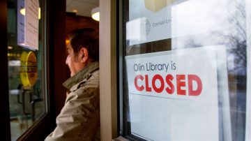 Man exiting Olin Library next to closed sign