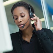 Person in a headset in front of a computer monitor