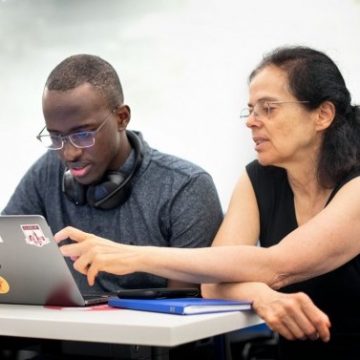 Professor pointing to a student's laptop screen