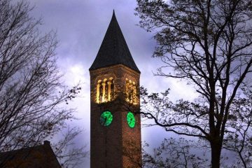 McGraw Tower with clockfaces lit green