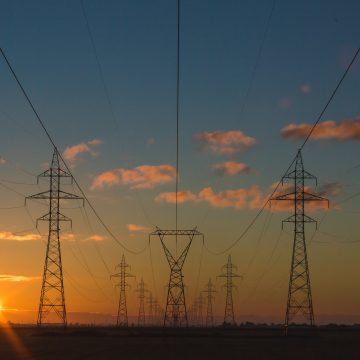 A field of power lines and towers at sunset