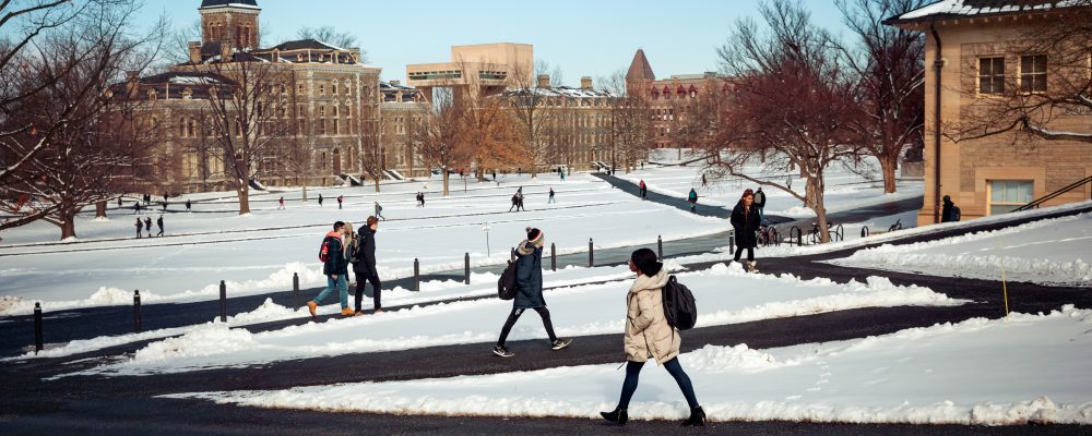 Students walk across the snowy arts quad