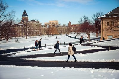 Students walk across the snowy arts quad