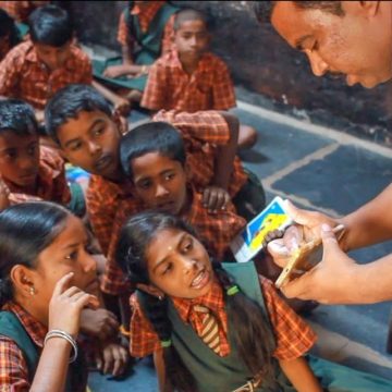 Teacher in India using a smartphone to teach children
