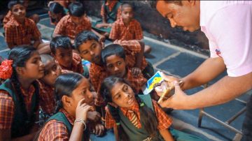 A teacher in a low-income school uses a smartphone to teach about soil.