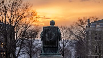 A.D. White statue looks across the Arts Quad at sundown.