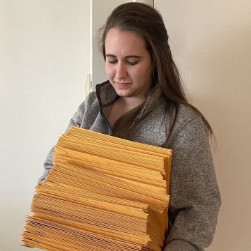 Caroline Steingard holds a stack of envelopes