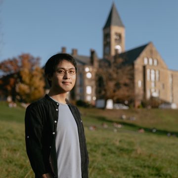 Xiangkun (Elvis) Cao with Cornell's McGraw Tower in the background