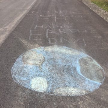 Chalk drawing of the Earth with text reading, "The Earth without art is just 'eh.' Happy Earth Day!"
