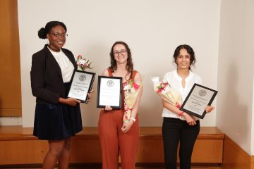Chinasa Okolo, a student from the Expanding Your Horizons organization, and Jumana Badar hold their plaques and bouquets