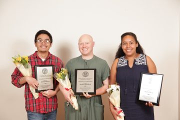Joshua Garcia, Andrew Scheldorf, and Karina Beras hold their plaques and bouquets