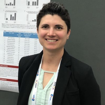 Emily Riddle stands in front of an academic poster