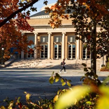 A student walks in front of Bailey Hall in the fall