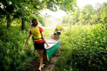 Two students carry a canoe