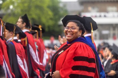 A doctoral candidate celebrates at the 2022 Commencement ceremony at Schoelkopff Field.