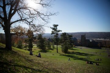 Students sit on Libe Slope on a late fall afternoon