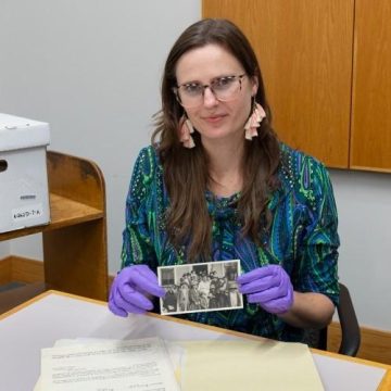 Lynda Xepoleas holds up a black and white photograph