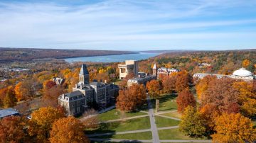 An aerial view of the Cornell Ithaca campus Arts Quad in fall with Cayuga Lake in the background