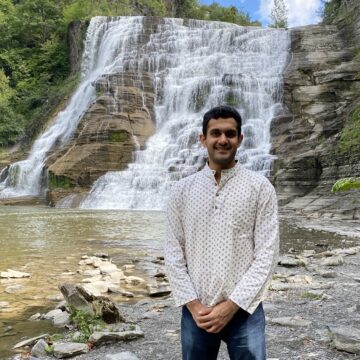 Dhruv Agarwal stands in front of Ithaca Falls