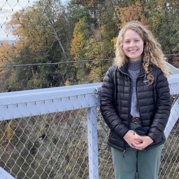 Kate on a campus suspension bridge in fall