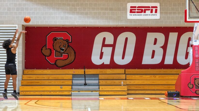 A student shoots a basketball on a Cornell court