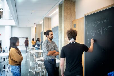 Graduate students in the Department of Physics work on equations in the Physical Science Building.
