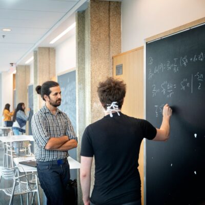 Graduate students in the Department of Physics work on equations in the Physical Science Building.