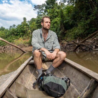 Ethan Duvall sits on the back of a canoe
