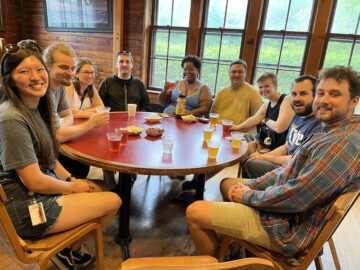 Students enjoy drinks around a table inside the Big Red Barn Graduate and Professional Student Center