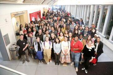 Group of people standing together in a foyer.