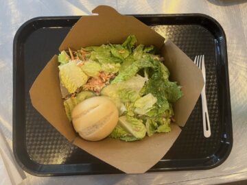 Salad with a roll on a tray