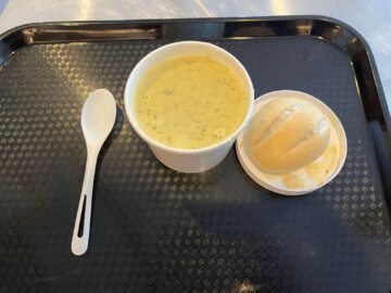 Soup and a dinner roll on a tray