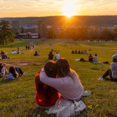 Students take in a fall sunset on Libe Slope.