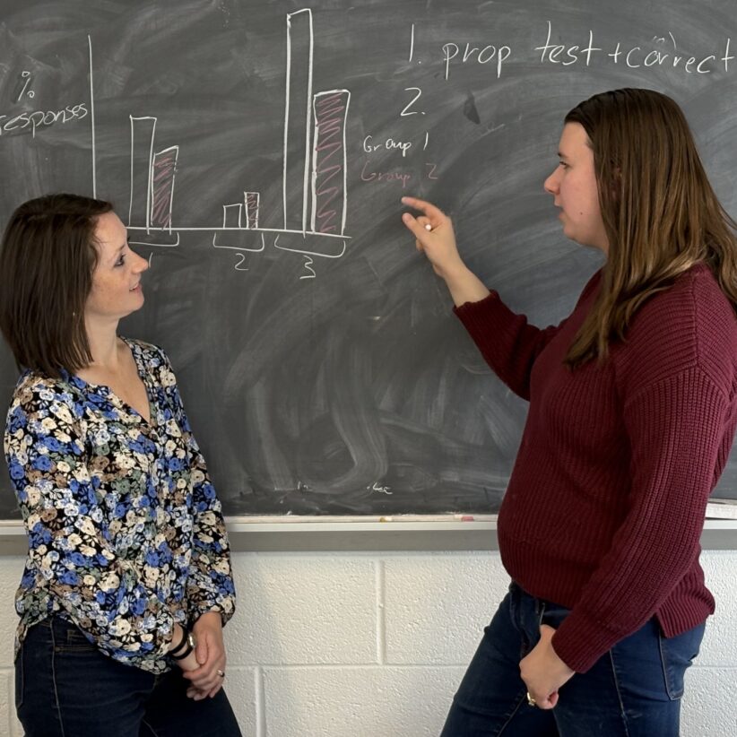 Natasha Holmes and Rebeckah Fussell work on a blackboard