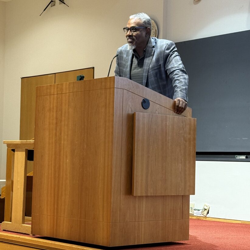 Wayne Scales stands behind a podium giving the Future Professors Institute keynote talk