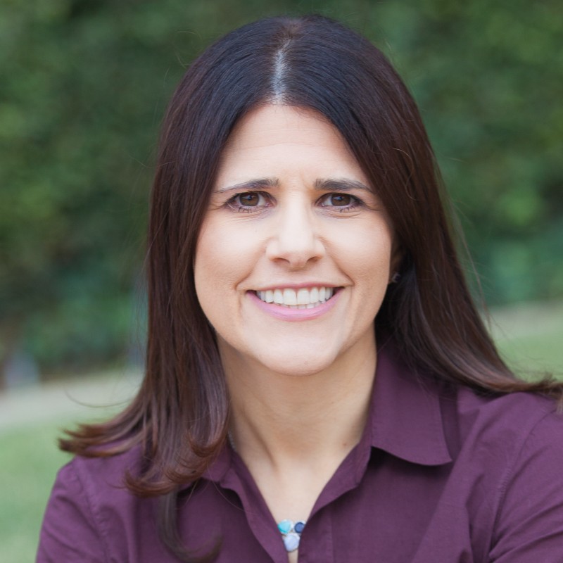 Professional photo of a woman in a burgundy shirt outside