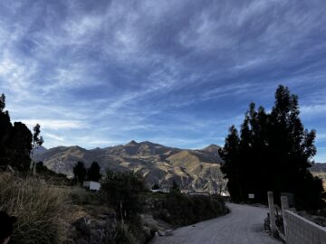 A path in the foreground winds toward mountains in the background
