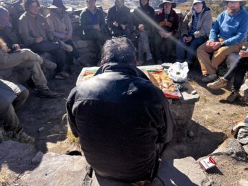 The town's shaman leads the Pago ceremony sits in front of the stone table during the Pago ceremony