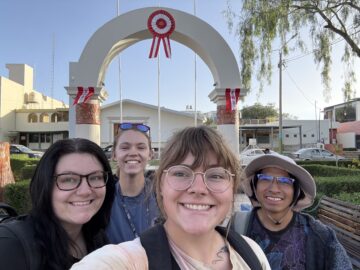 Holly Sexton and three other archaeologists stop for a selfie in front of an archway