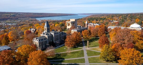 An aerial view of Cornell's Ithaca campus in fall with Cayuga Lake in the background