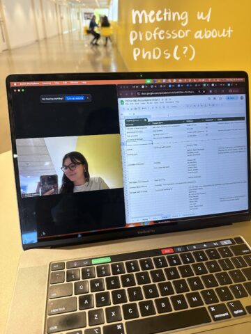 A laptop is open to a Zoom screen and Google sheet