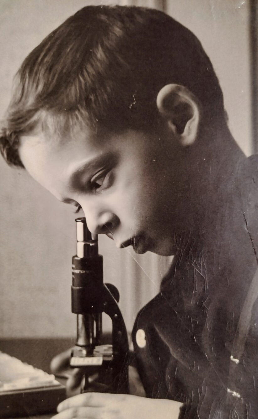A young Andrew Kligerman looks through a microscope