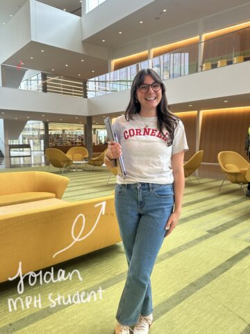 Jordan Deskins stands in the Vet College building wearing a Cornell shirt
