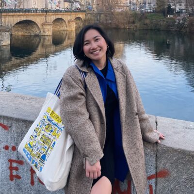 Everlynn Khamjoi stands on a bridge with a river in the background
