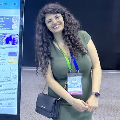 Lyn Zemberekci stands next to a poster at an academic conference